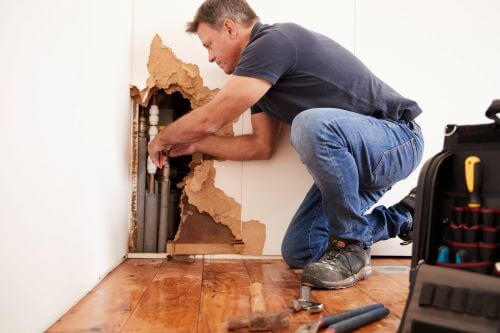 man attempting to repair water damage because he did not use a public adjuster for his claim