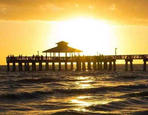 sunset behind public pier in lee county